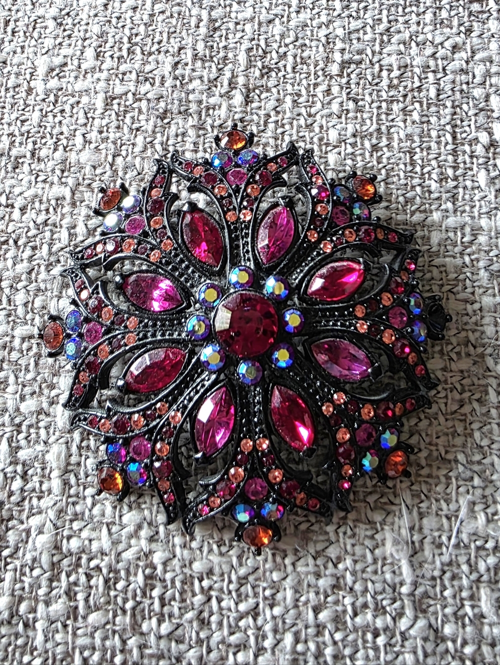 Joan Rivers brooch featuring wine red, pink, & iridescent rhinestones.
